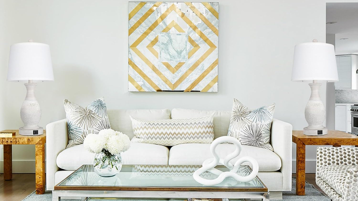 Modern living room with white sofa, glass coffee table, and decorative items.